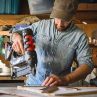 artist using nail gun on wooden art at workshop - nails art stock pictures, royalty-free photos & images