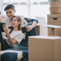 asia chinese couple sitting on floor resting after opening carton cardboard boxes in living room moving house - home decoration stock pictures, royalty-free photos & images