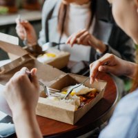 asian businesswomen having take away food during lunch break - junk food stock pictures, royalty-free photos & images