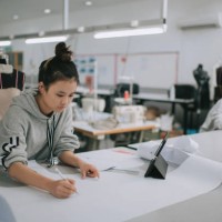 asian chinese female fashion college student writing down measurement and drawing sewing pattern doing clothing project at college workshop - fashion stock pictures, royalty-free photos & images