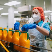 asian chinese female juice factory worker tighten bottle cap in production line - food stock pictures, royalty-free photos & images