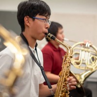 asian chinese teenage boy junior high student playing saxophone in band class in school orchestra - concert stock pictures, royalty-free photos & images