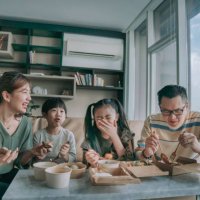 asian chinese young family enjoying take out food in front of tv in living room during weekend - junk food stock pictures, royalty-free photos & images
