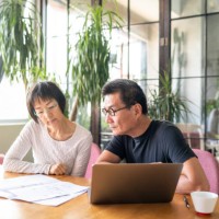 asian couple looking at blueprints of their new house - home decoration stock pictures, royalty-free photos & images