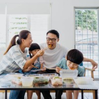 asian family having take out food in living room - junk food stock pictures, royalty-free photos & images