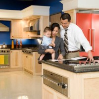 asian family looking at brochure in kitchen showroom - home decoration stockfoto's en -beelden