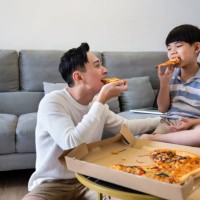 asian father and son enjoy pizza food delivering using credit card purchase at home. - junk food stock pictures, royalty-free photos & images