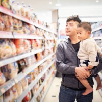 asian father carrying his baby to a supermarket - junk food stock pictures, royalty-free photos & images