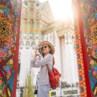 asian female traveler enjoying view of famous wat pho in bangkok - travel stockfoto's en -beelden