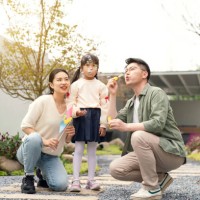 asian little girl playing soap bubbles with her mother and father outdoors. - garden decoration stock pictures, royalty-free photos & images