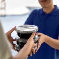 asian man delivering food in black boxes to customer home. - food stock pictures, royalty-free photos & images