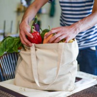 asian man unpacking groceries at kitchen island - food stock pictures, royalty-free photos & images