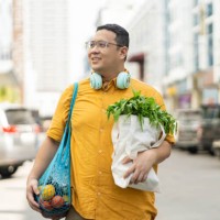 asian man walking on street with groceries on hands - food stock pictures, royalty-free photos & images