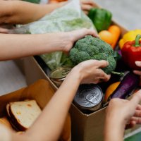 asian volunteers packing donated goods and groceries at food bank - food stock pictures, royalty-free photos & images