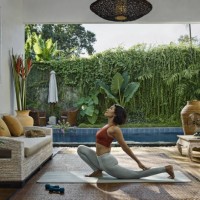 asian woman practicing yoga during home workout in open living room, in front of pool garden - garden decoration photos et images de collection