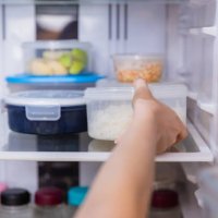 asian woman stored leftovers food in plastic container put into refrigerator. - food stock pictures, royalty-free photos & images