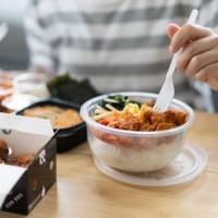 asian young adult order takeaway bibimbap and fried chicken korean style korean food and cuisine delivery food service for lunch at home - junk food stock pictures, royalty-free photos & images