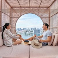 asiatisches paar entspannt sich und lacht in einer cabana am hotelpool - travel stock-fotos und bilder