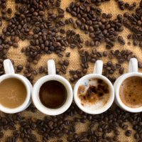 assorted coffee drinks in cups on coffee beans background - coffee stockfoto's en -beelden