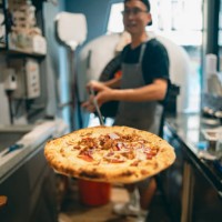 at the restaurant, a pizza chef is preparing pizza on the workstation. - junk food stock pictures, royalty-free photos & images
