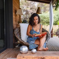 attractive middle eastern woman reading a book on a terrace in the summer - home decoration stock pictures, royalty-free photos & images