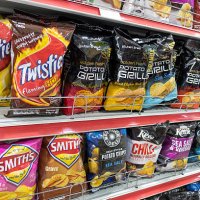 Australia, Sydney, Central Business District CBD convenience store shelves food junk snack potato chips bags competing brands packaging sale retail...