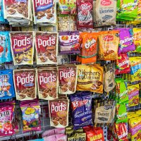 Australia, Sydney, Haymarket EzyMart convenience store snacks junk food display sale candy chocolate bags competing brands packaging.