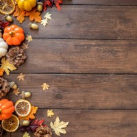 autumn modern decorated wooden table for thanksgiving or halloween with pumpkins, dried orange slices. bright colorful with gold details. overhead view of gourds, dry leaves, shot on rustic wooden table. thanksgiving backgrou