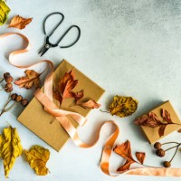autumnal gift box tied with a ribbon and dried autumn leaf decorations on a table - home decoration stock pictures, royalty-free photos & images