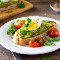 avocado toast with eggs and roasted tomatoes - food stock pictures, royalty-free photos & images