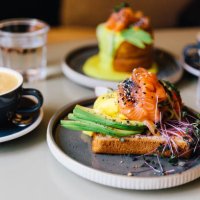 avocado toast with salmon and poached egg served for breakfast at a cafe - food stock pictures, royalty-free photos & images