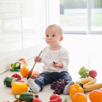 baby making mess on floor with food - food stockfoto's en -beelden