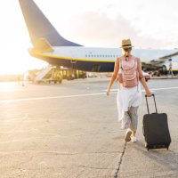 back view of a woman walking towards the plane, ready to board and begin her vacation - travel stock pictures, royalty-free photos & images