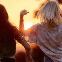 back view of carefree women dancing on music festival at sunset. - concert stock pictures, royalty-free photos & images