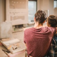 back view of embraced couple in their renovating apartment. - home decoration stock pictures, royalty-free photos & images