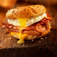 bagel, bacon, sausage and egg breakfast sandwich - junk food stock pictures, royalty-free photos & images