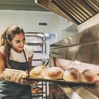 baker pulling a tray with hot bread - food stockfoto's en -beelden
