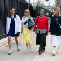 Barbara Ines wears a white jacket, a blue mini polo dress, white socks, blue heeled slingback and a white leather bag, in the middle a guest wears a...