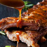 barbecue sauce dripping on marinated and grilled spare ribs - food stockfoto's en -beelden
