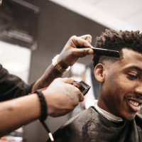 barber giving a haircut in his shop - hairstyle stock pictures, royalty-free photos & images