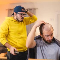 barber messed up while giving a haircut to his client at home because of the pandemic - hairstyle stockfoto's en -beelden