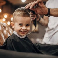 barbero secando el cabello del niño después de cortarle el pelo en la barbería - hairstyle fotografías e imágenes de stock