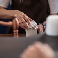 barista closing lid of disposable coffee cup - junk food stock pictures, royalty-free photos & images