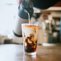 barista giet melk in koude brouwsel koffie - coffee stockfoto's en -beelden