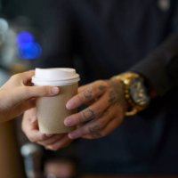 barista serving coffee in takeaway paper disposable cups to client in coffee shop - junk food stock pictures, royalty-free photos & images