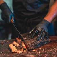 bbq chef cuts deliciously tender smoked brisket slices. - food stock pictures, royalty-free photos & images