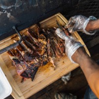 bbq chef cutting smoked pork ribs for his food truck or catering company - junk food stock pictures, royalty-free photos & images
