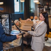 beautiful asian female personal assistant picking up a food delivery order - junk food stock pictures, royalty-free photos & images