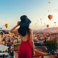 beautiful asian woman watching colorful hot air balloons flying over the valley at cappadocia, turkey. turkey cappadocia fairytale scenery of mountains. - travel stock pictures, royalty-free photos & images