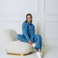 beautiful fashion model woman in glasses posing sitting in a chair in a room in a new collection of clothes. lady in room looking at camera in studio shot - fashion stock pictures, royalty-free photos & images